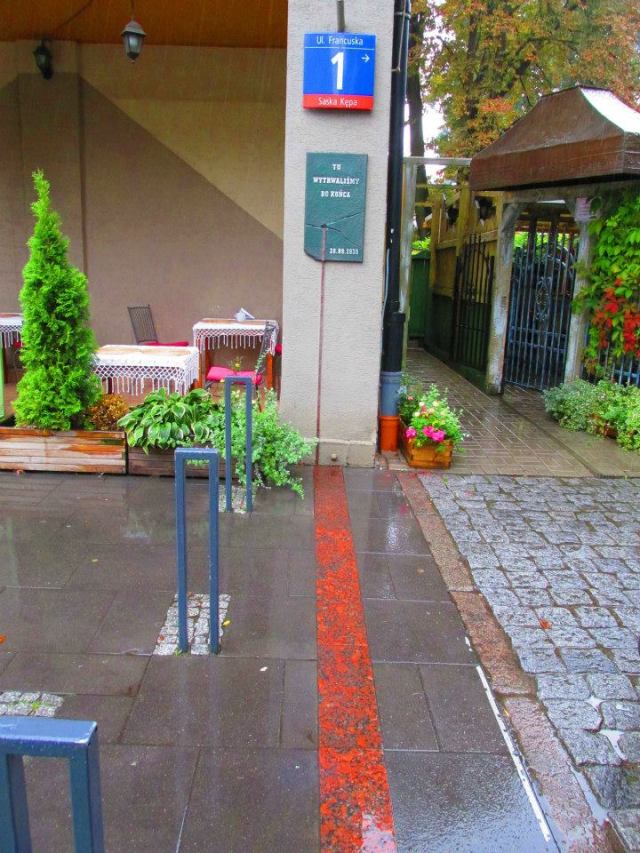 Miejsce w którym przebiegała barykada oznaczono na chodniku.